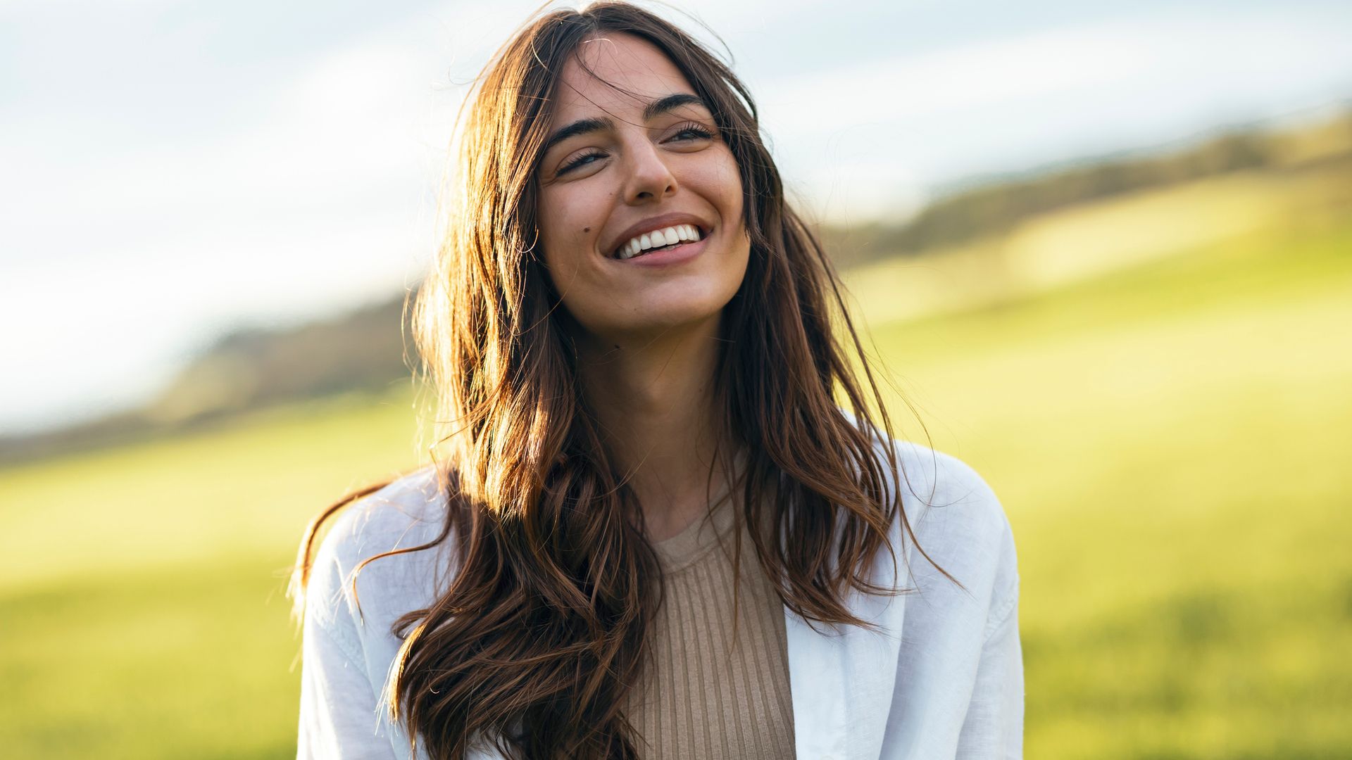 Mujer feliz y serena sonriendo en el campo 