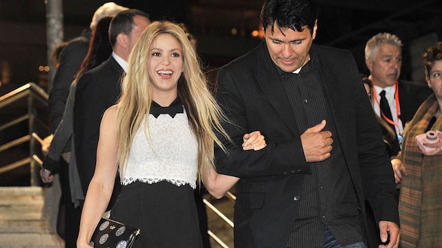 Plano medio de Shakira con su hermano Tonino en un evento bajando escaleras
