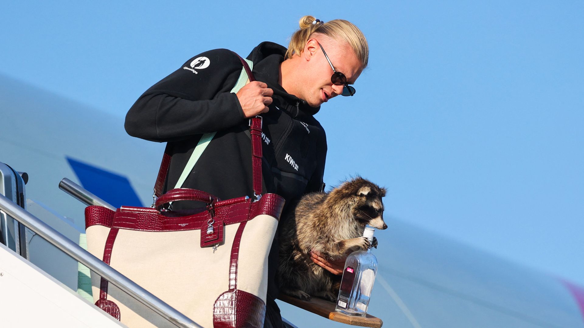Erling Braut Haaland fue captado descendiendo del avión que lo llevó de regreso a casa con un curioso recuerdo: la figura de un mapache sujetando una botella de licor.