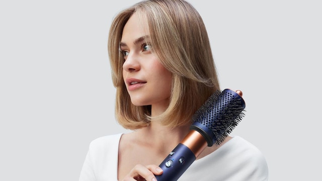 Mujer con pelo corto peinando su cabello con moldeador de pelo Dyson