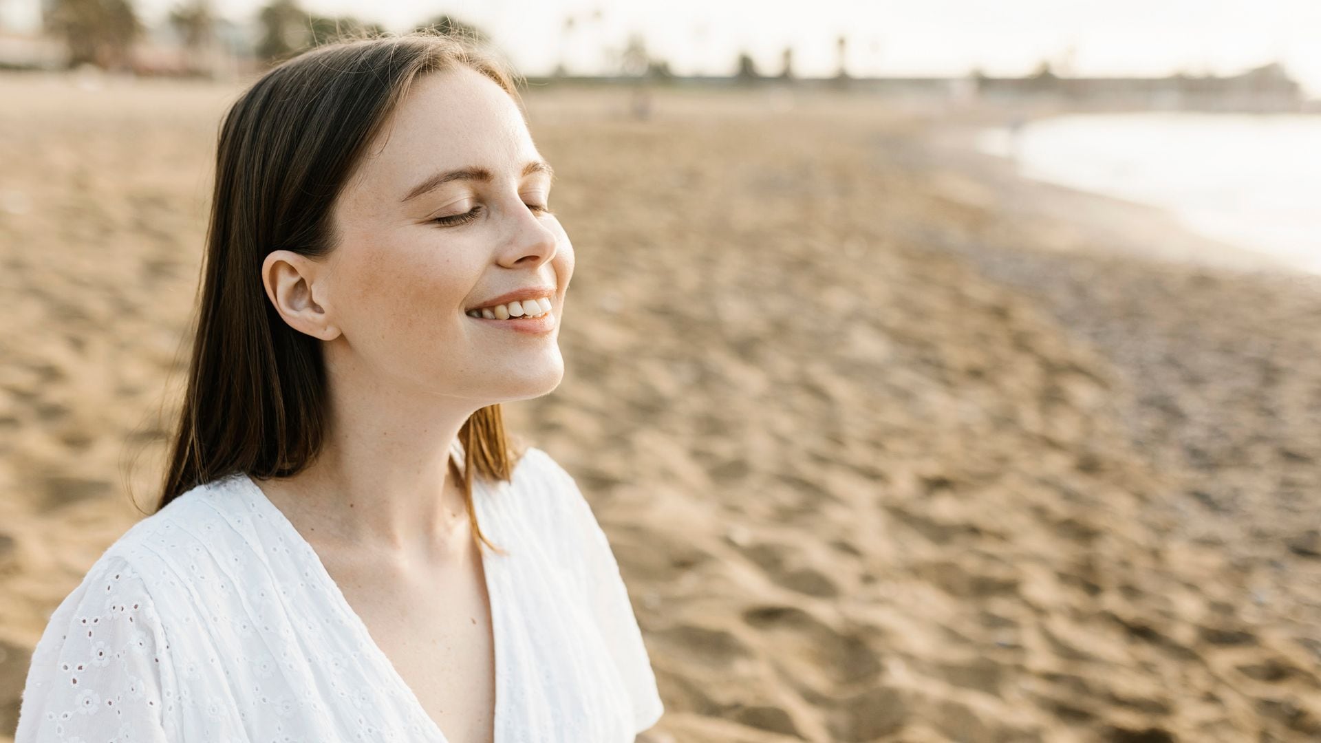 Mujer respirando tranquila en la playa 