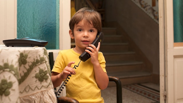 Niño llama por teléfono en casa