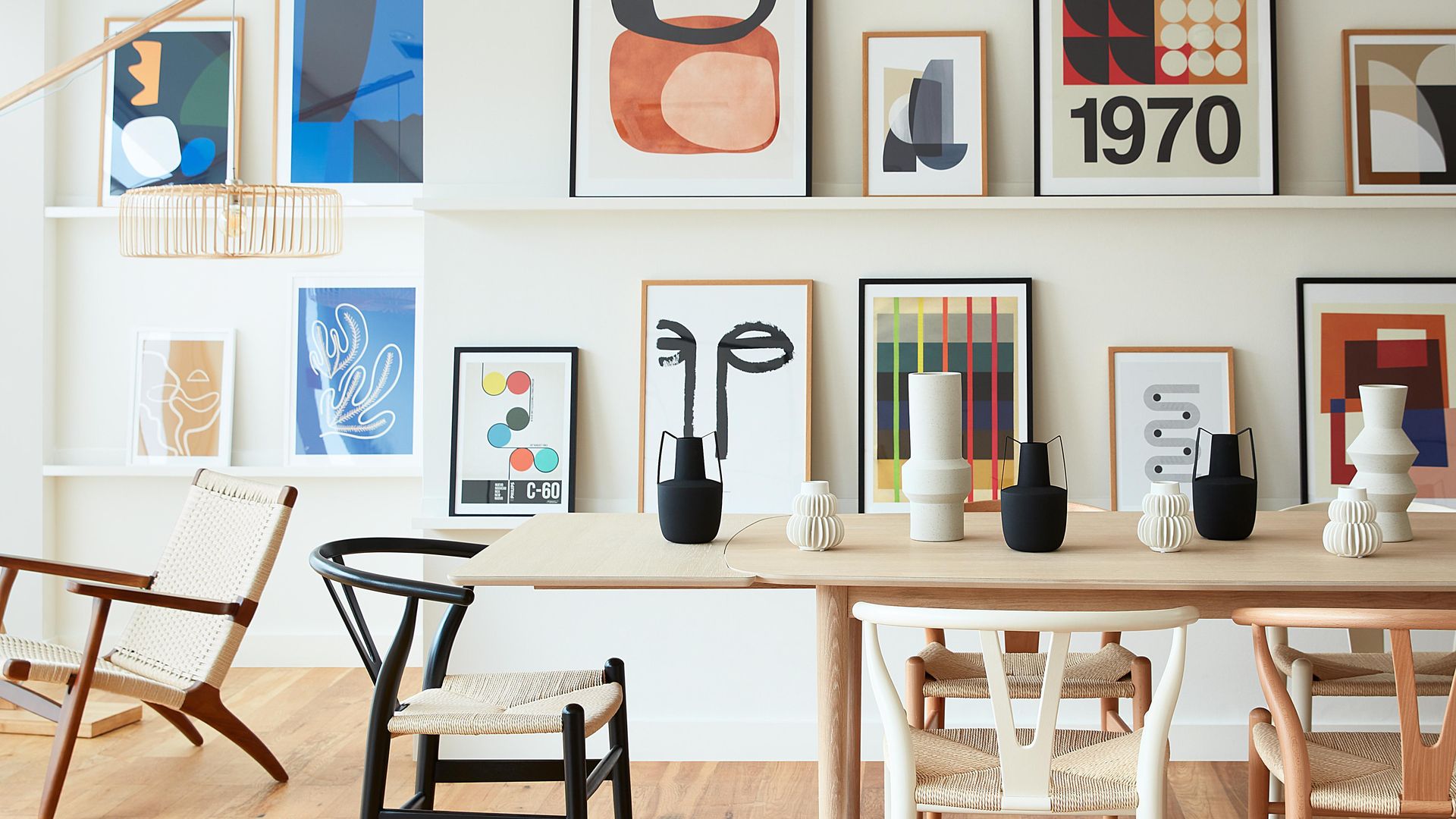 Pared decorada con composición de láminas en baldas