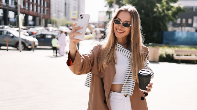 Mujer con 'outfit' otoñal y un termo de café en la vuelta a la oficina