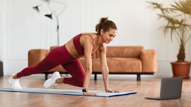 mujer haciendo mountain climber en el salón de su casa