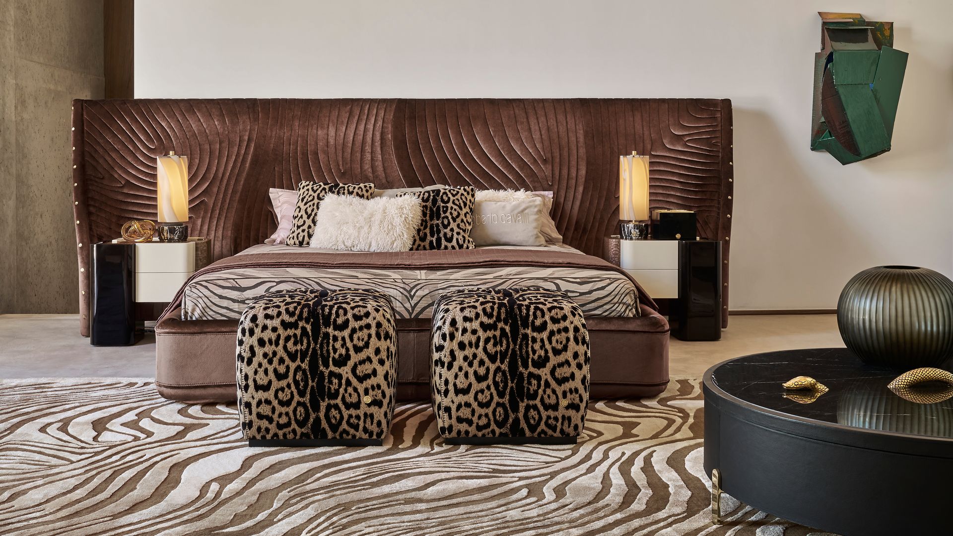 Dormitorio con cabecero tapizado en marrón, alfombra y cojines y pufs de estampado de leopardo