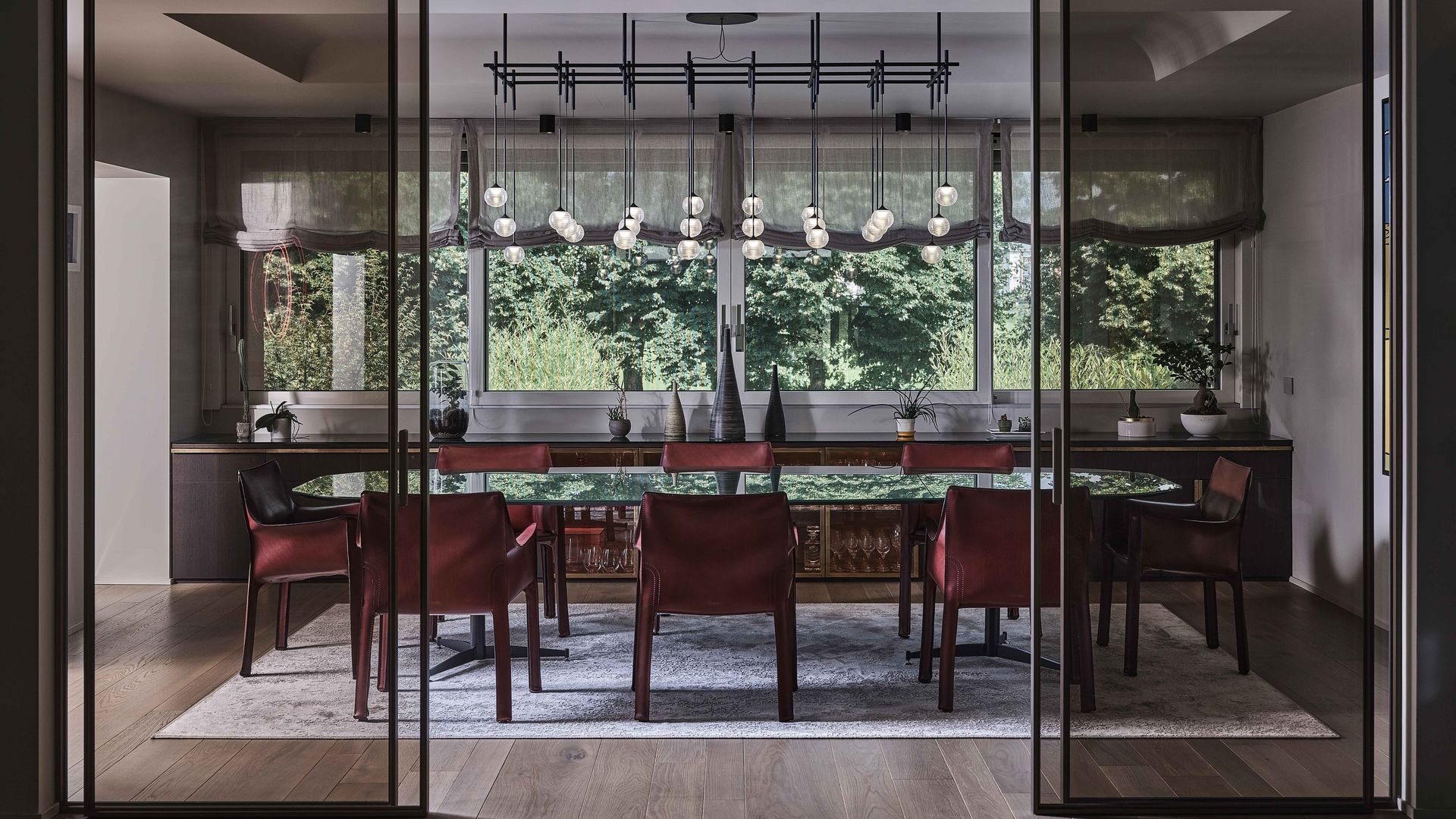 Comedor independizado mediante correderas de cristal, alfombra y lámpara de techo 