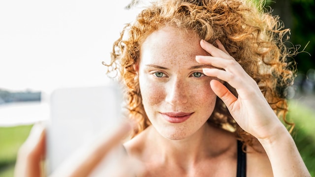 Chica pelirroja con pecas haciendose una foto