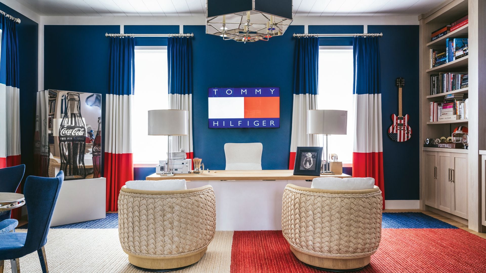 Oficina temática de Tommy Hilfiger con sillas tejidas blancas, escritorio y estanteria de libros