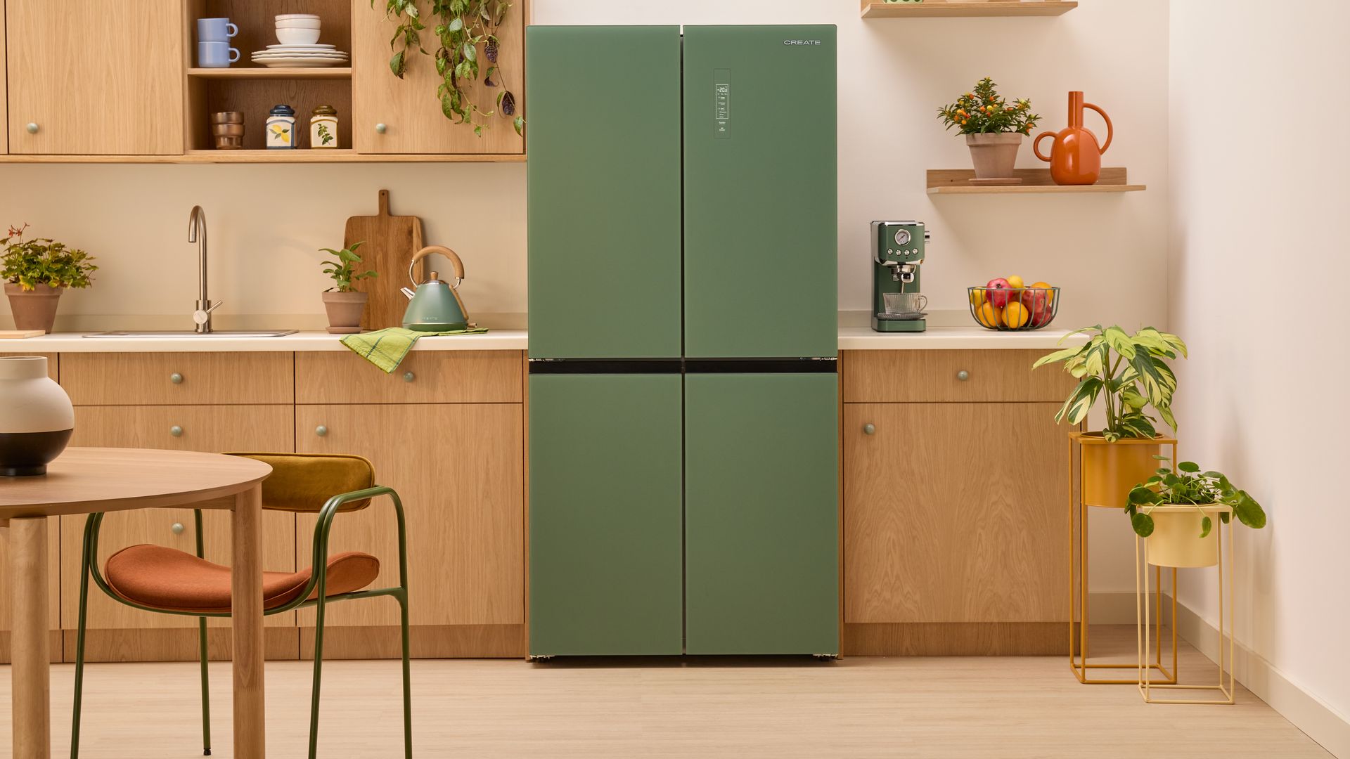 Cocina de madera con comedor, con frigorífico verde, plantas, baldas 