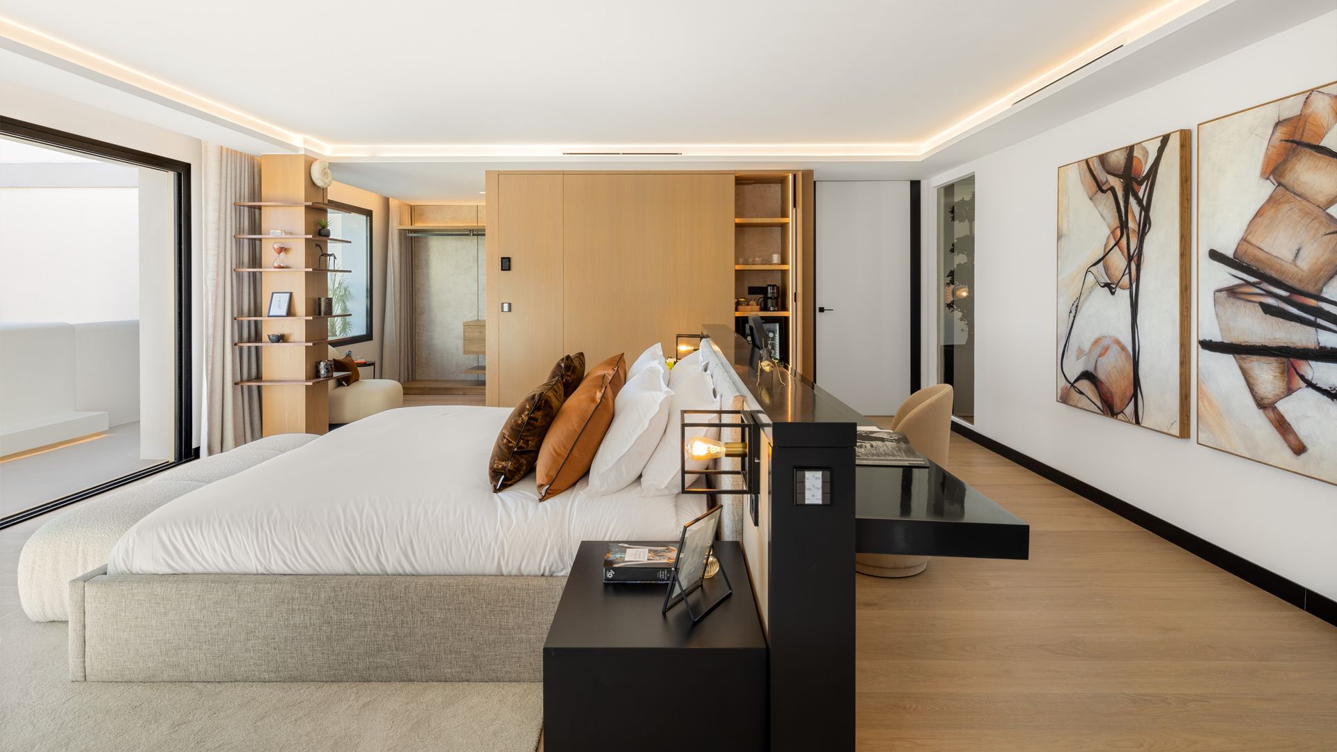 Dormitorio XL con cabecero con zona de escritorio en la parte trasera, cyadris en la pared, cama tapizada, ventanal, armario de madera con módulo abierto, estantería de madera, suelo de madera
