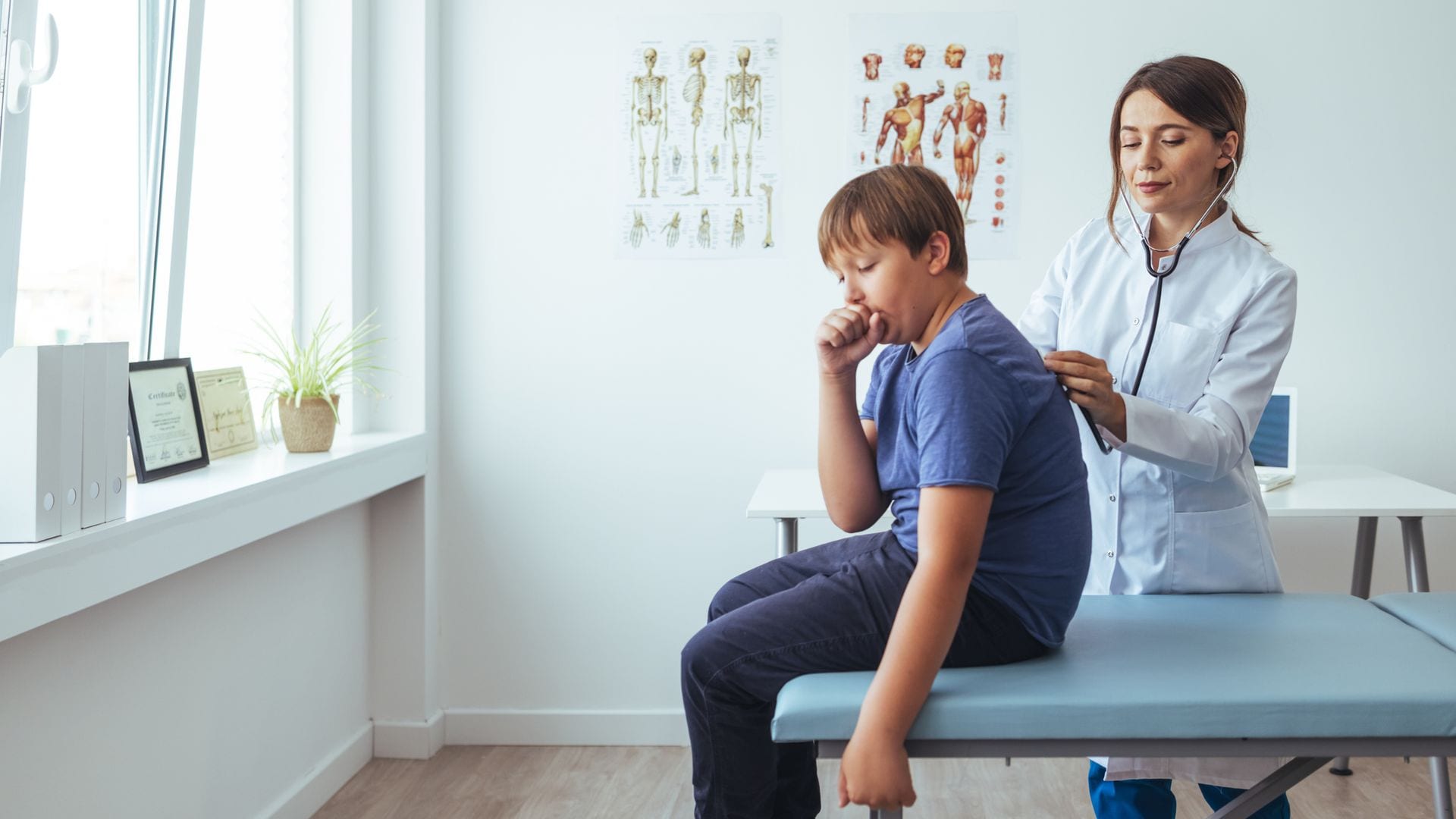 Pediatra explora a un niño con tos