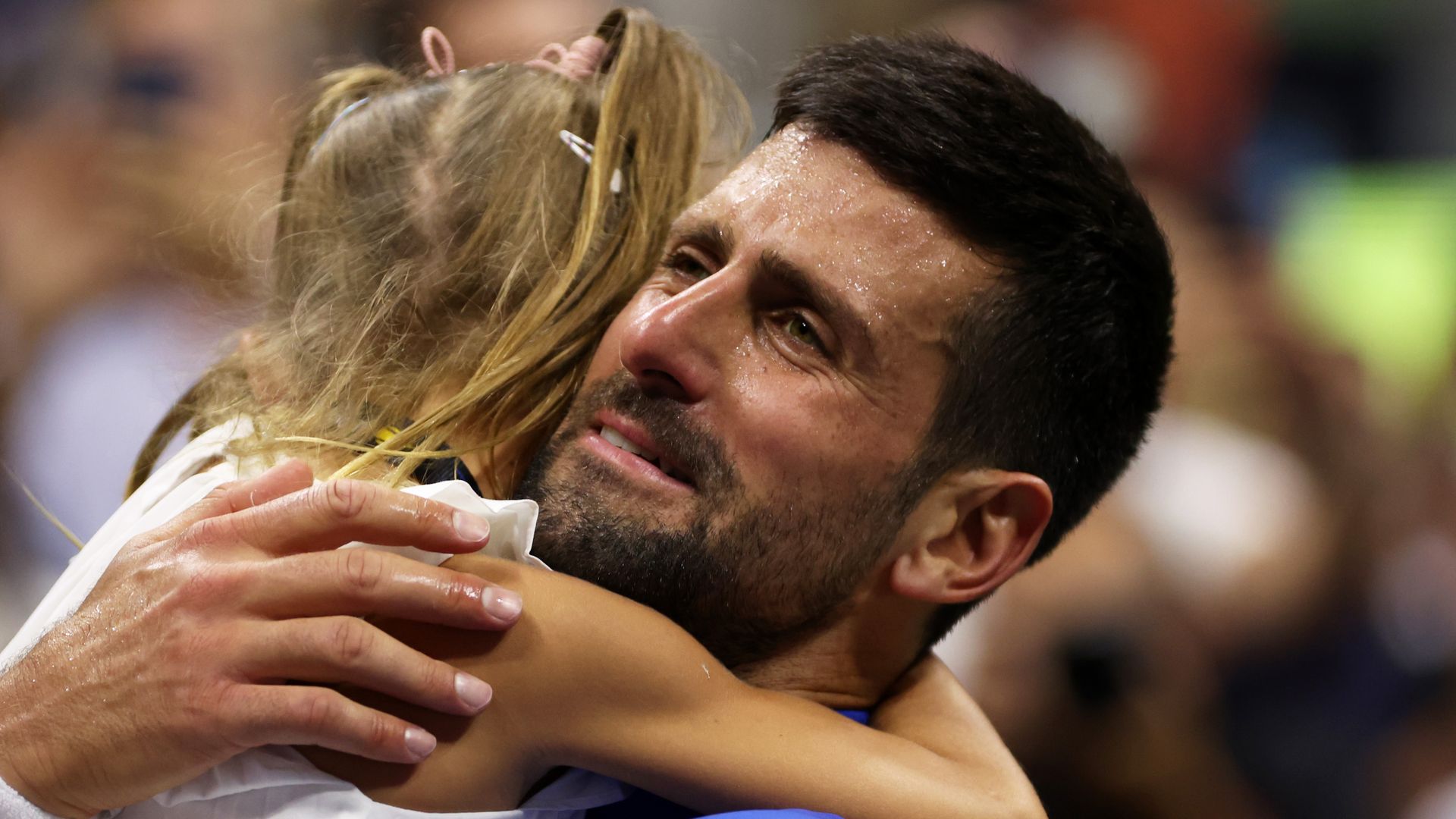Novak Djokovic llevando en brazos a su hija Tara tras un partido en 2023