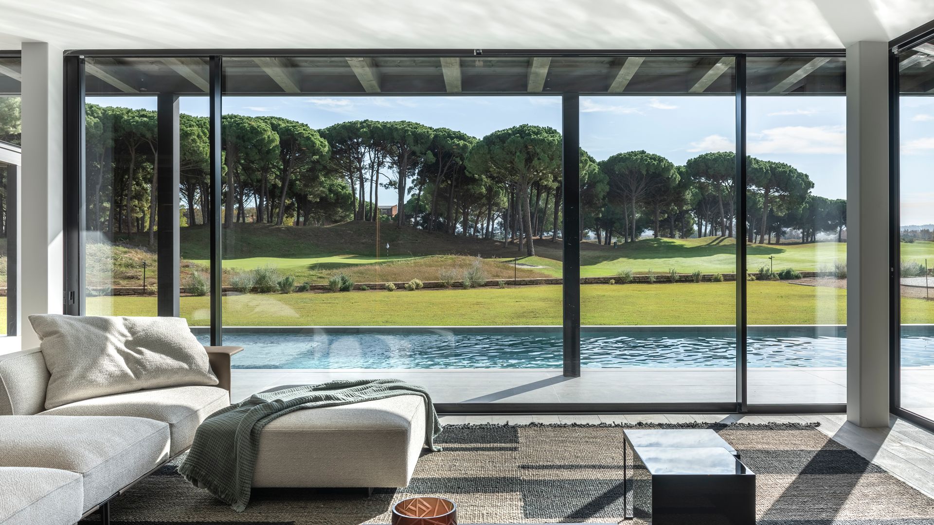 Salón conectado con el exterior con piscina, diseño de Ferruz Studio