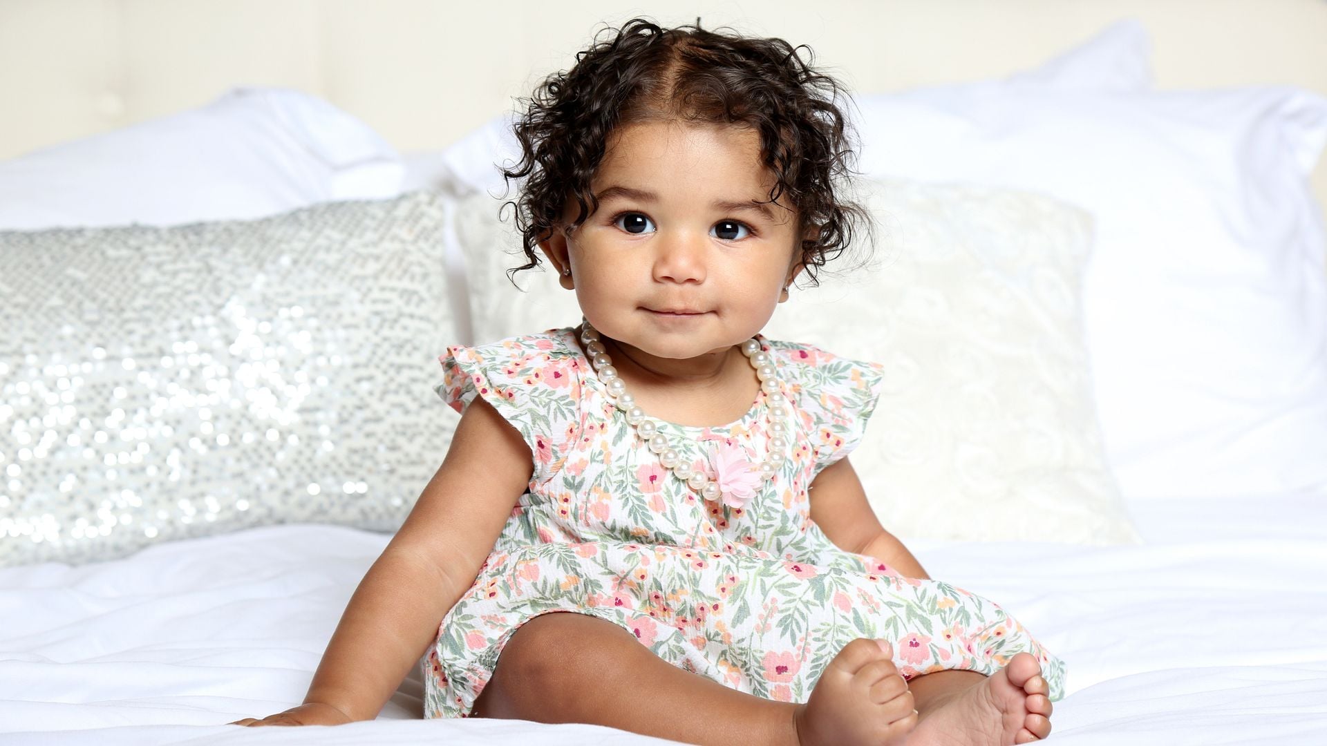 Bebé niña sentada en la cama