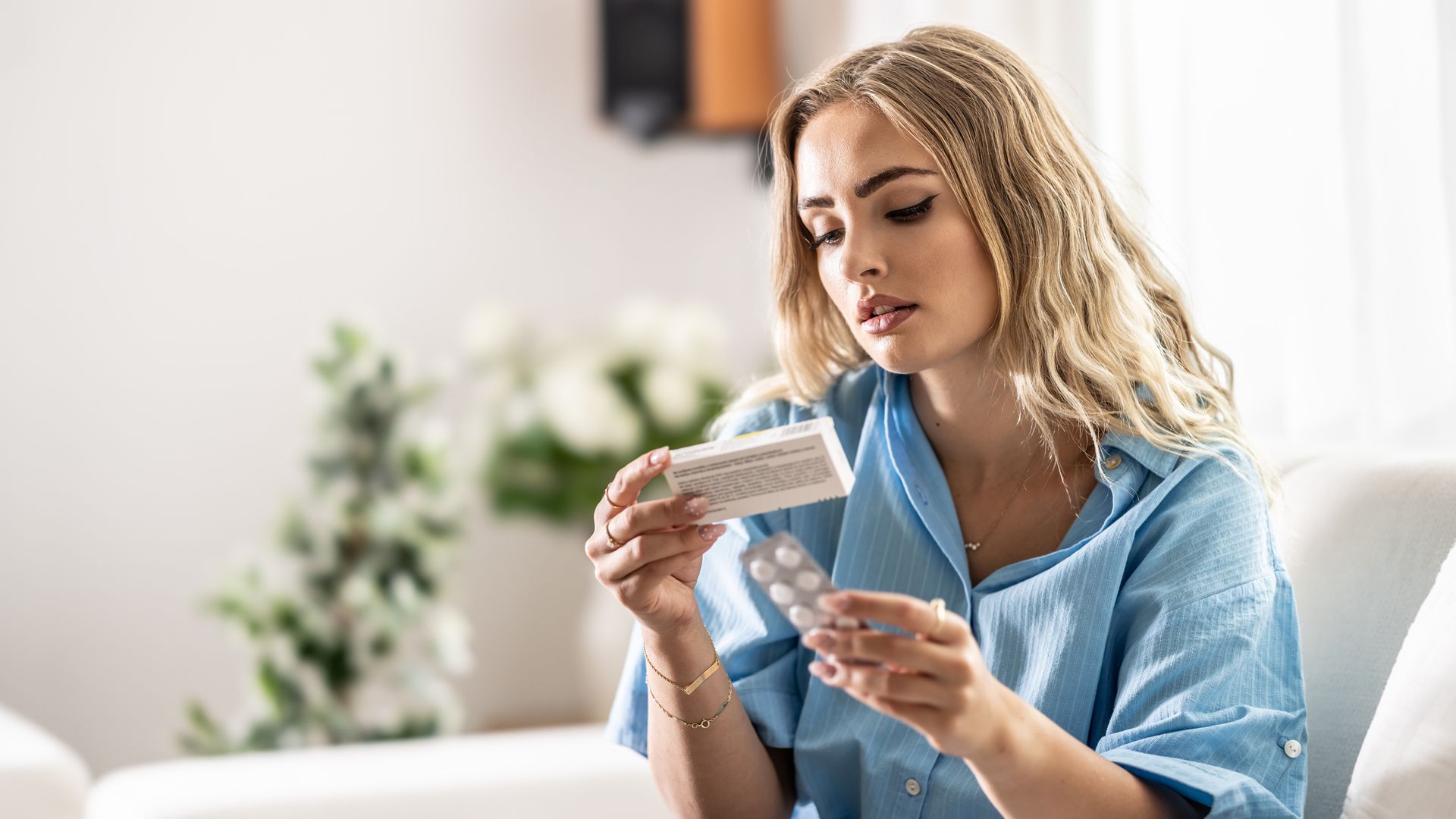 Mujer joven revisando el prospecto de un medicamento