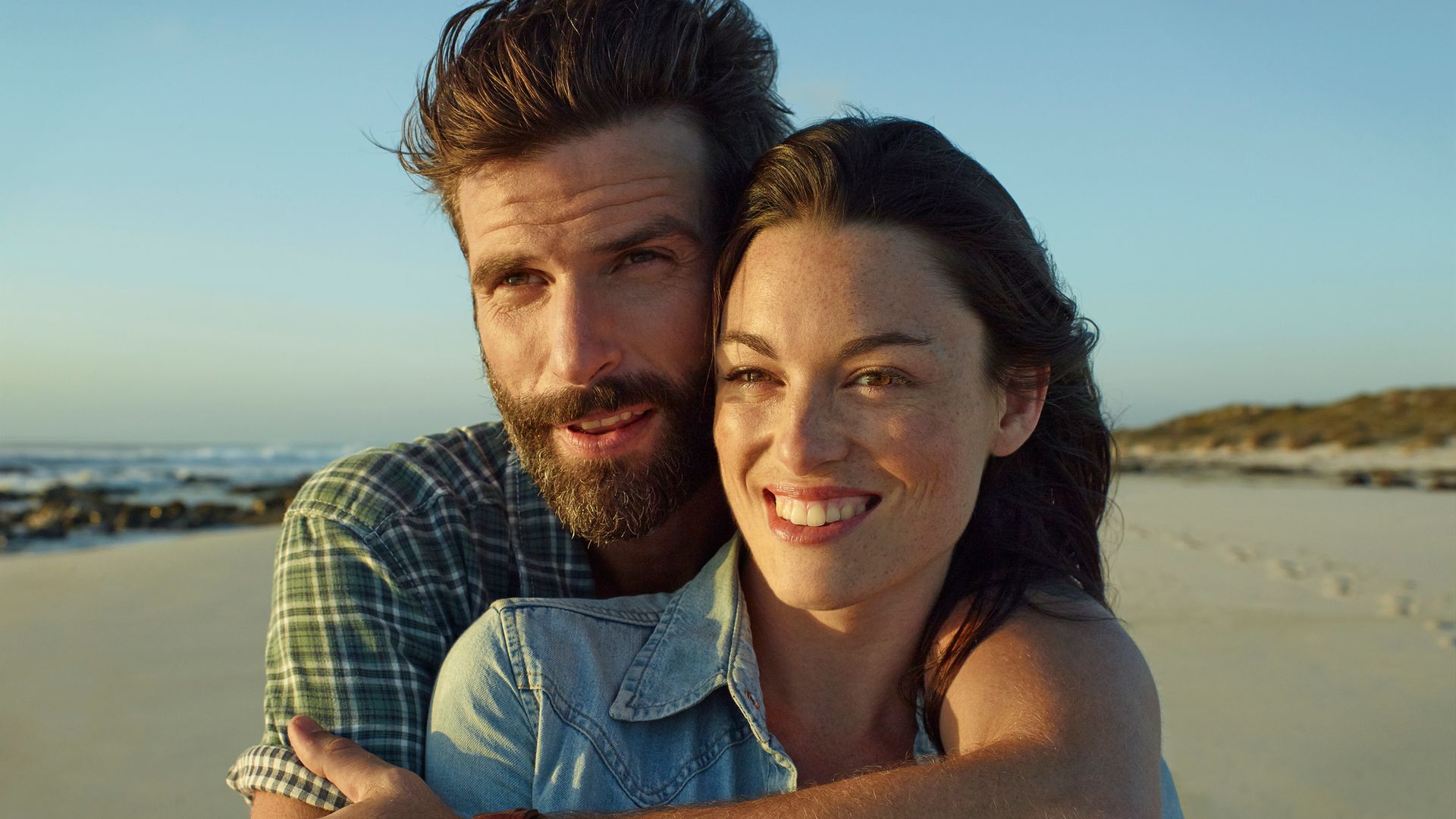 Pareja joven feliz en la playa
