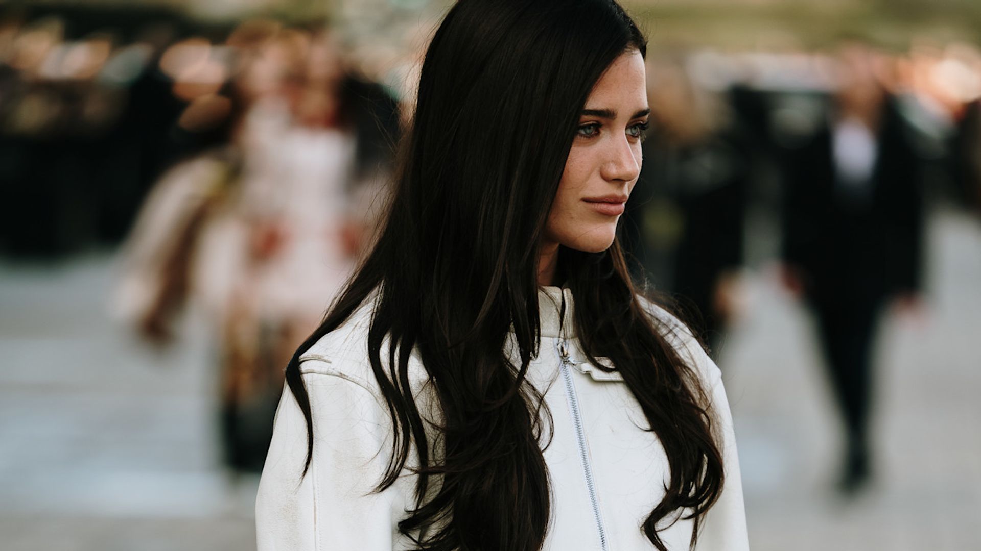 Invitada en París con abrigo blanco y pelo moreno