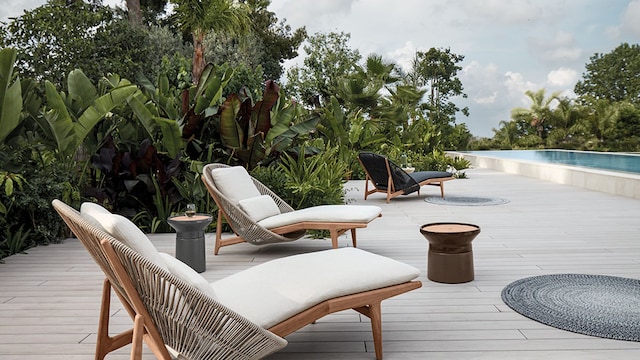 Terraza con tumbonas y plantas junto a la piscina