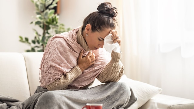 mujer enferma en casa, con un proceso gripal, dolor de cabeza y congestión nasal