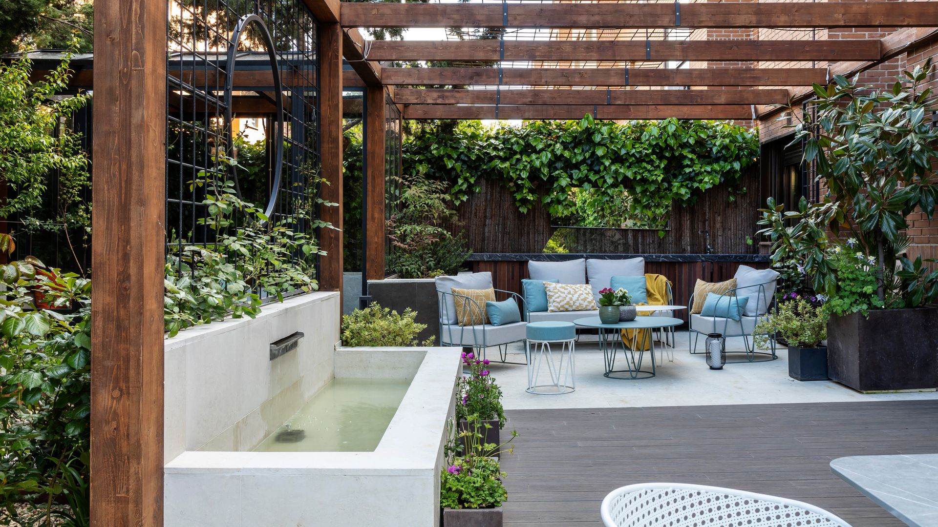 Las claves de este precioso jardín urbano: la exuberante vegetación, las texturas y un refrescante estanque