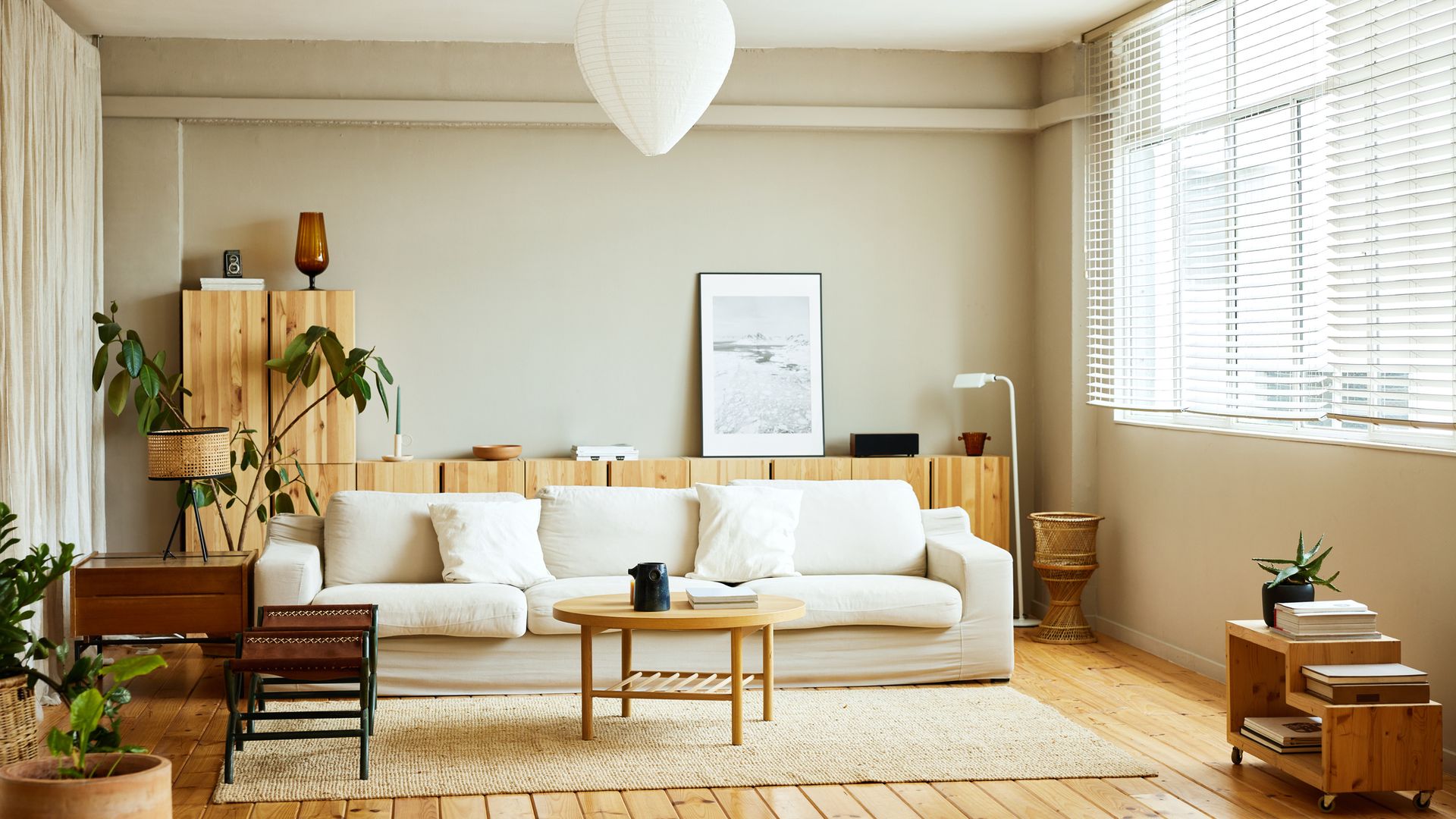 Interior de un apartamento amplio y luminoso decorado con maderas naturales, colores neutros y plantas. 