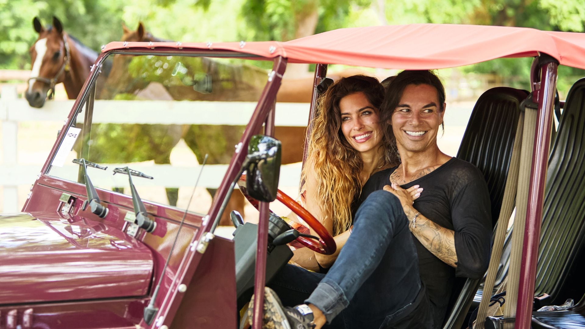 Julio Iglesias, Jr. y Ariadna Romero, posando juntos en un coche