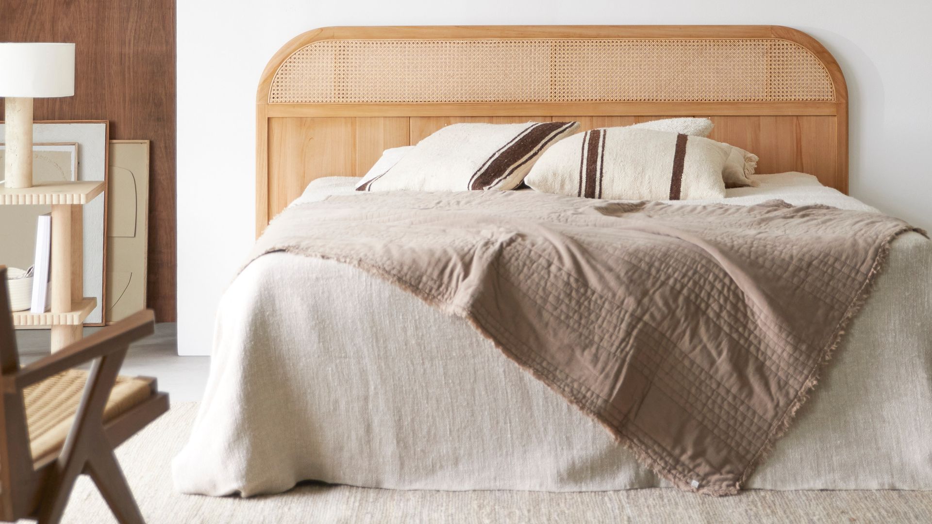 Dormitorio con cabecero de madera con la parte superior de rejilla, alfombra y ropa de cama blanca