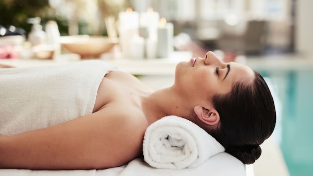 Relax, sleep and girl at luxury spa for massage, reiki service or aromatherapy for holistic treatment. Self care, peace and zen, woman on bed for facial wellness and alternative skincare at hotel.