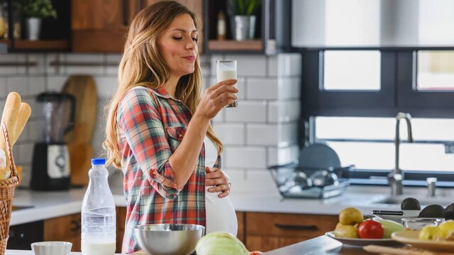 mujer embarazada tomando un vaso de leche