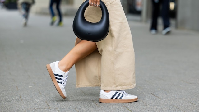 Jacqueline Zelwis con falda beis y zapatillas blancas de Adidas en Berlin
