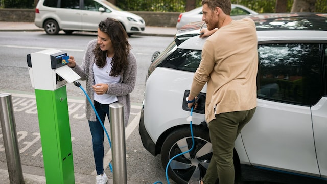 Pareja cargando un coche eléctrico