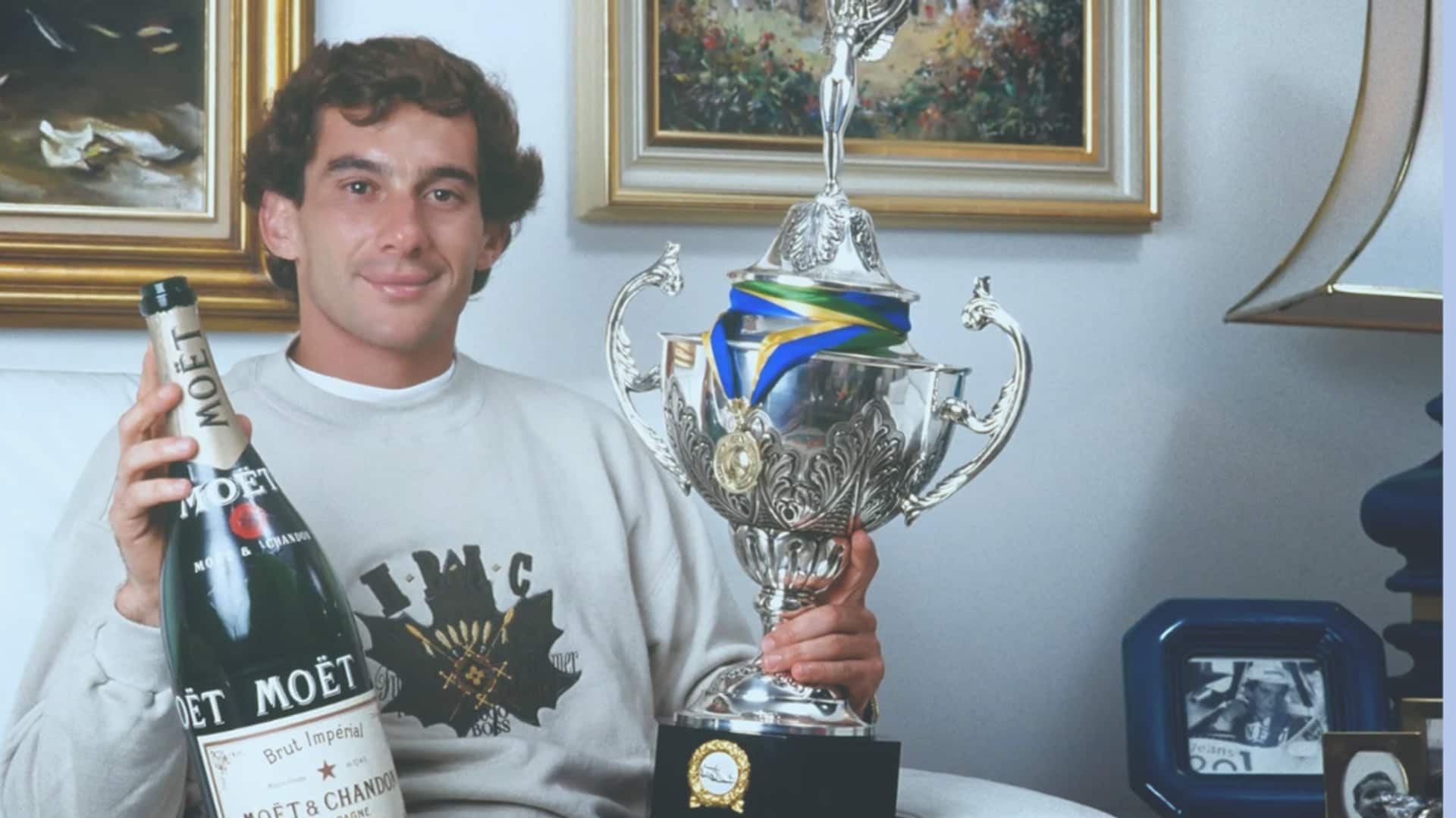 Ayrton Senna, campeón de Fórmula 1 con una copa de una de sus victorias y una botella de champán Möet Chandon.