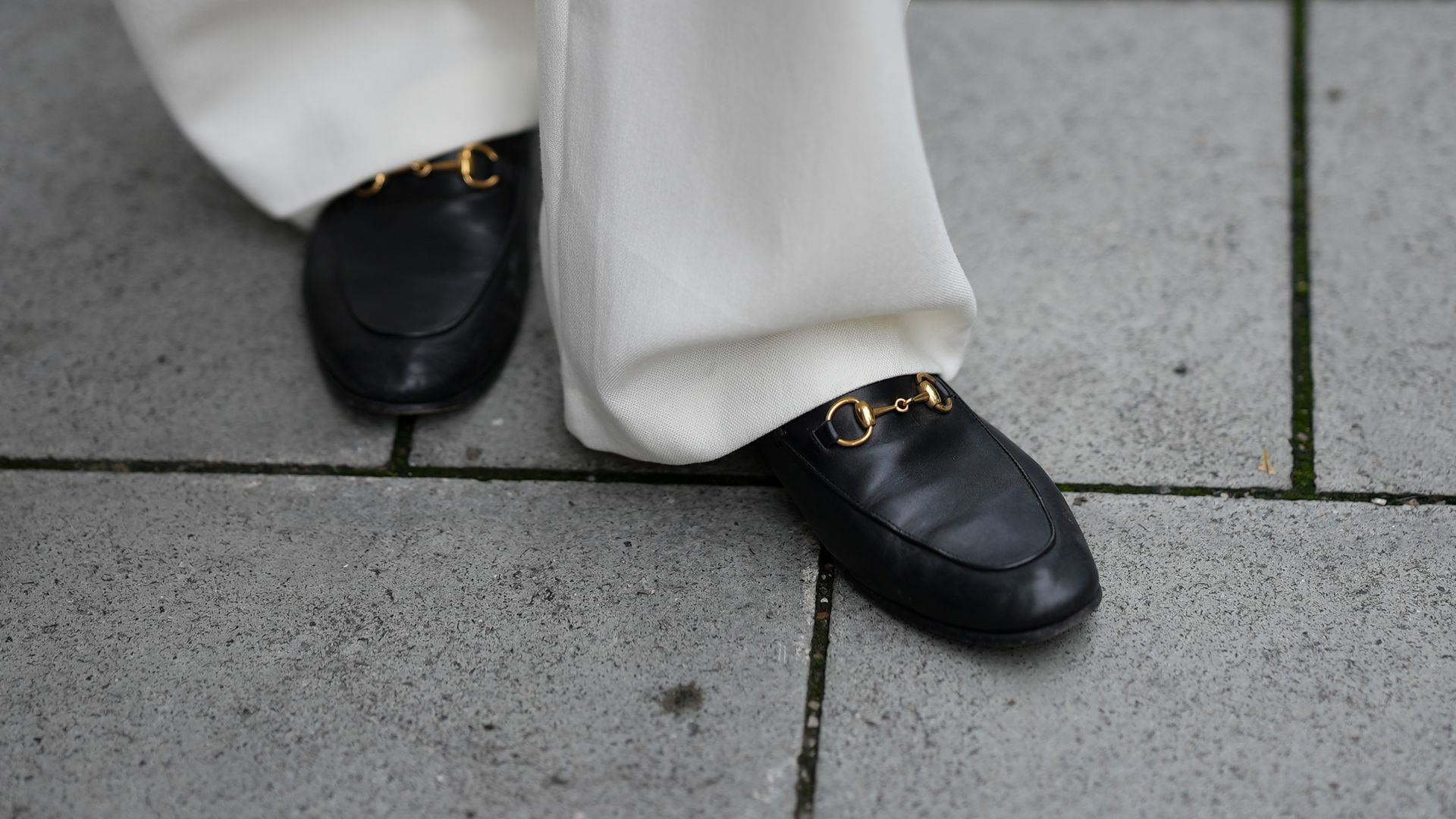 Fotografía de unos mocasines negros y pantalón blanco