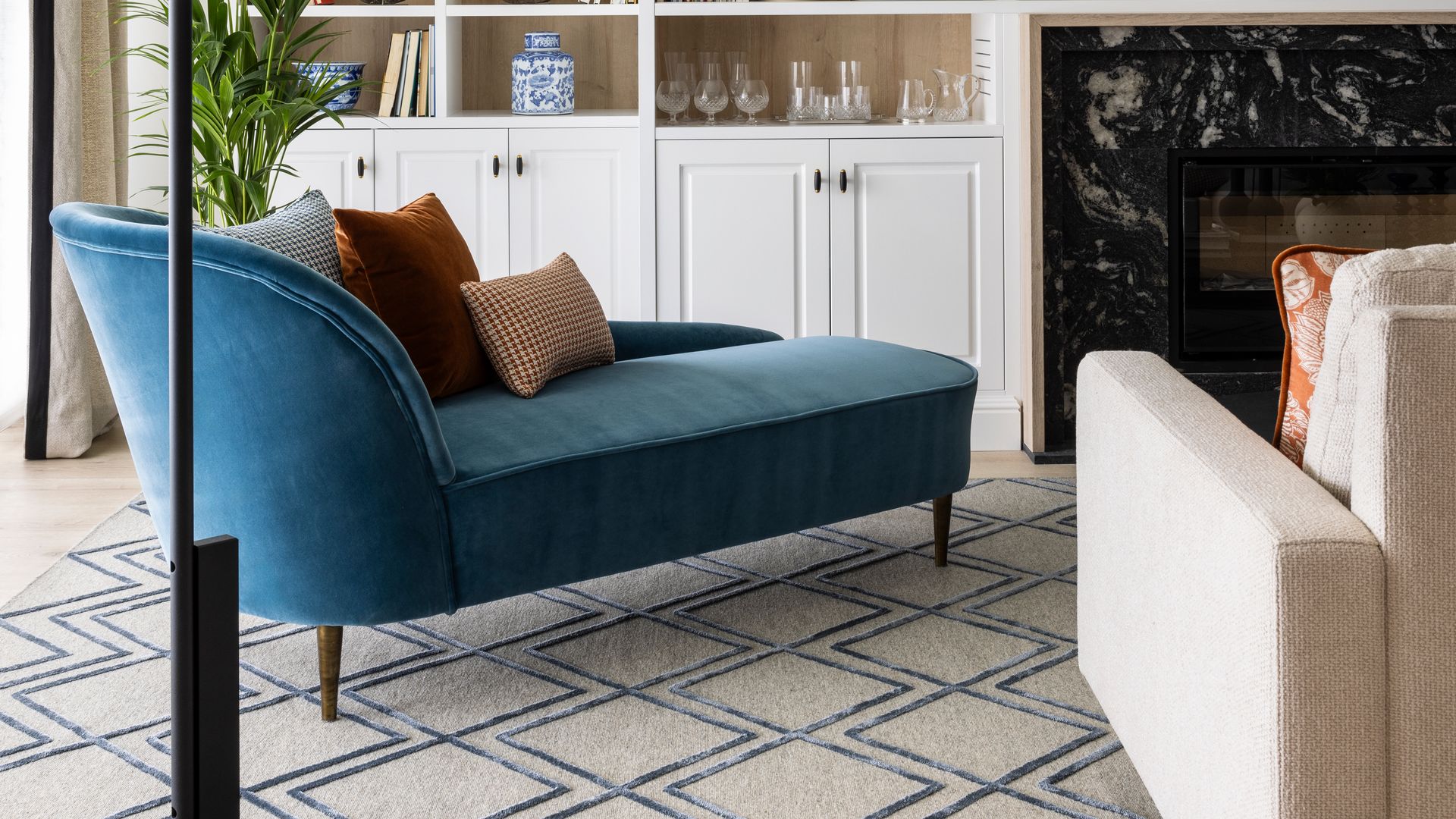 Salón con chaise longue tapizada en azul