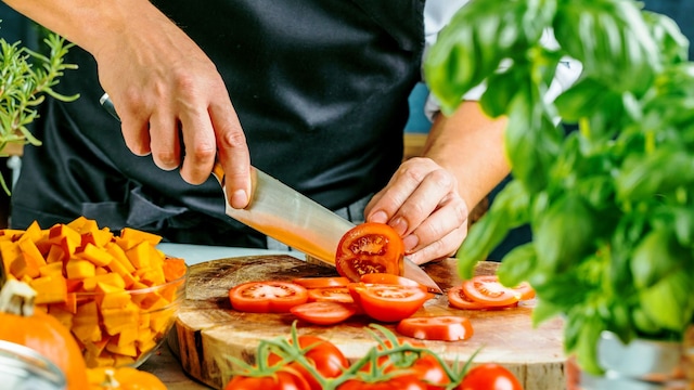 Chef cortando verduras con cuchillo