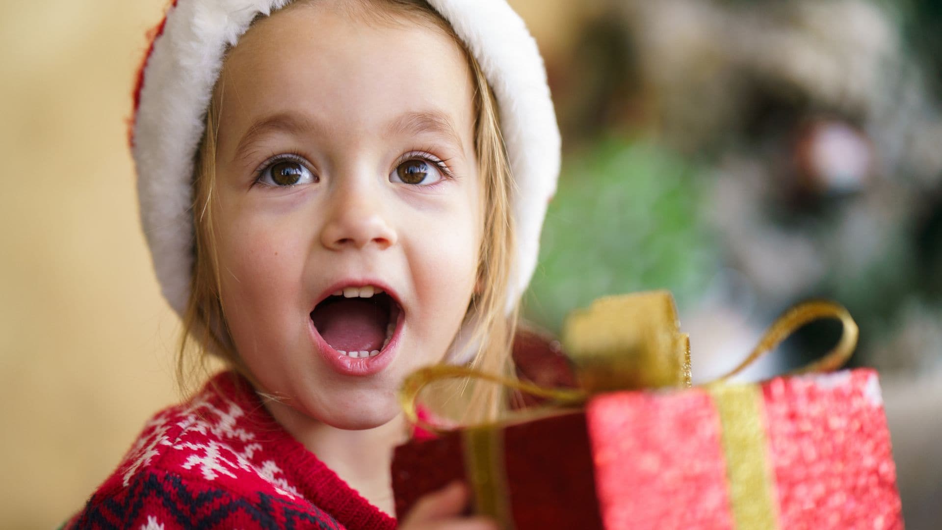 Niña feliz al abrir su regalo de Papá Noel