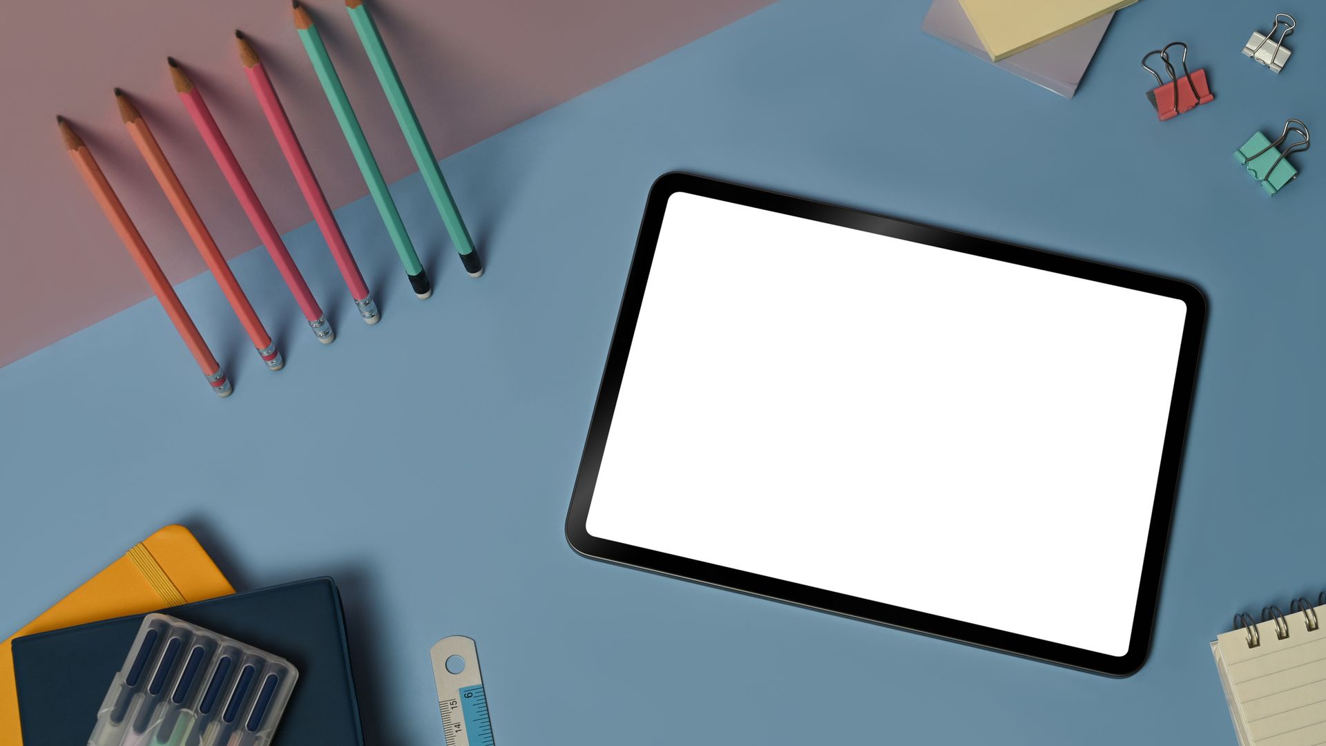 Una tablet sobre una mesa con material escolar