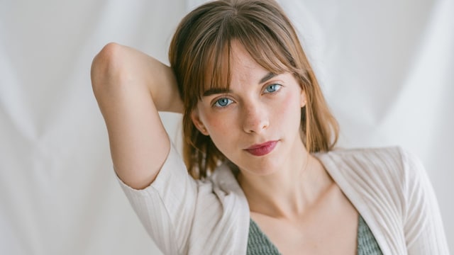 Mujer de ojos azules mirando a cámara callada y tranquila