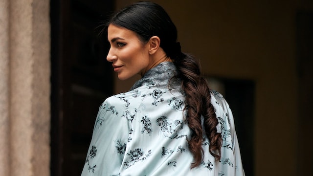 Invitada en la Semana de la Moda de Milán con kaftán azul y coleta con tirabuzón