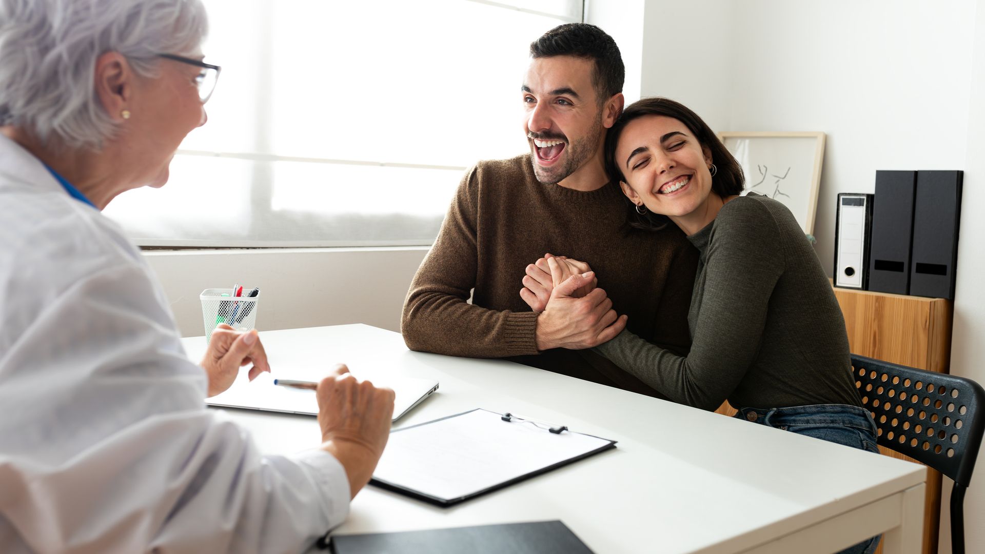 Pareja feliz en la consulta de una clínica de fertilidad