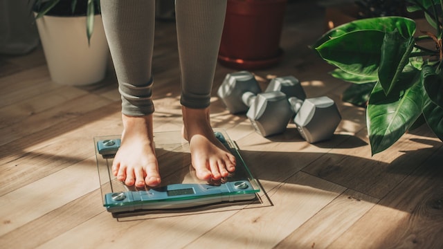 mujer pesándose en la báscula