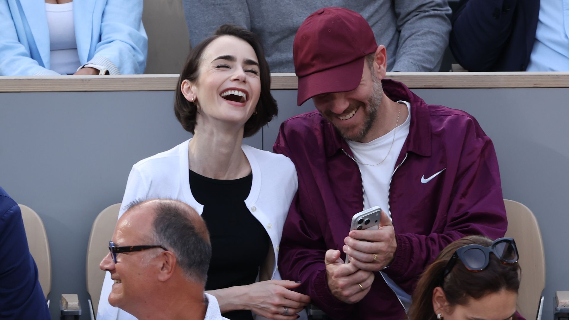 Lily Collins y su esposo disfrutando del partido.
