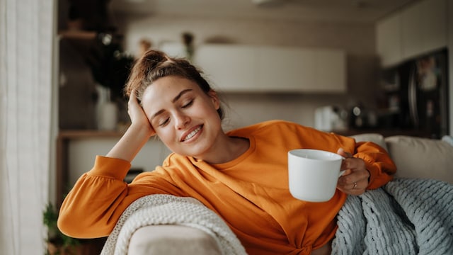 Mujer tomando té en el sofá 