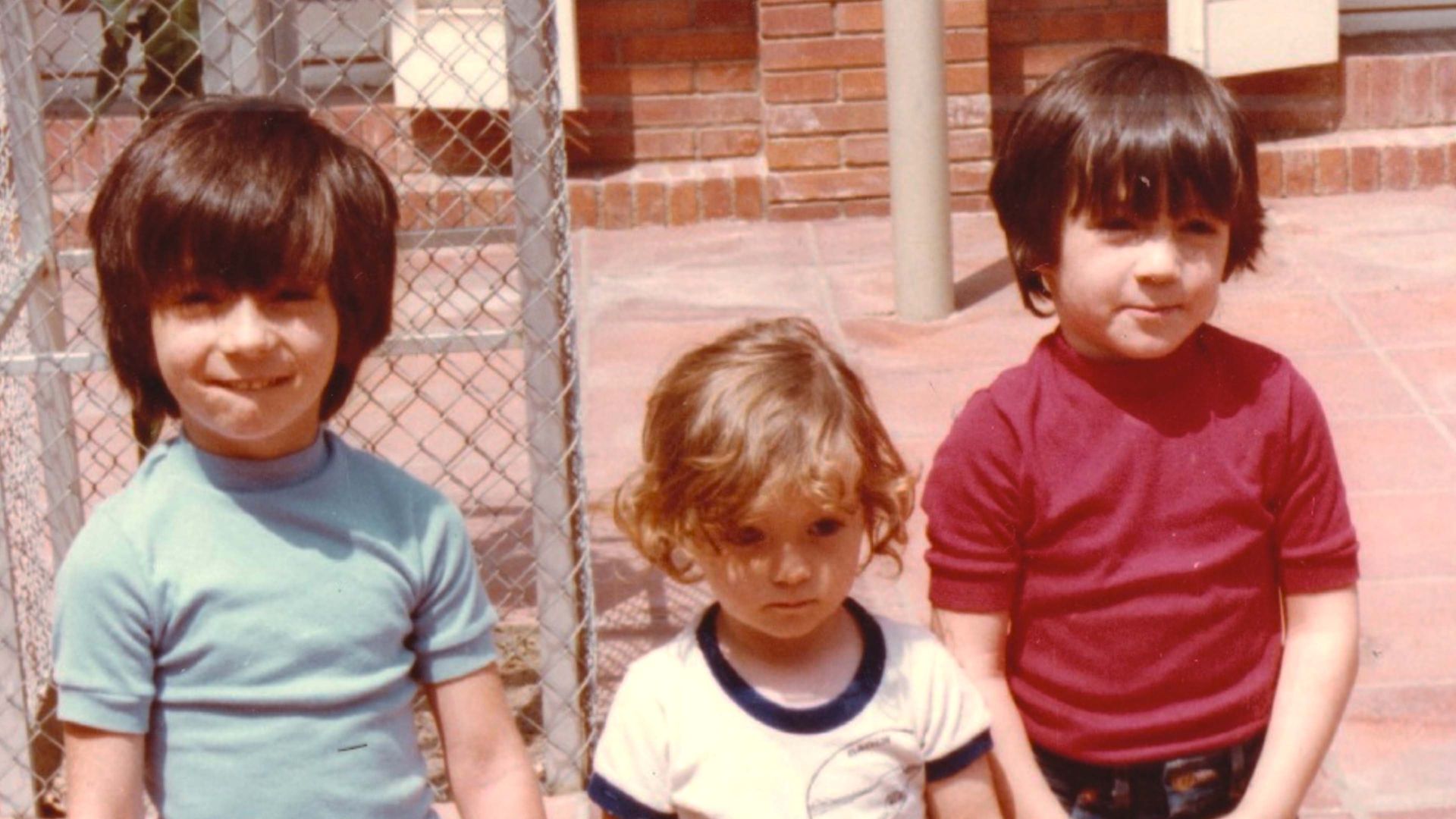 Una foto del archivo personal al que tenemos acceso durante la serie documental, donde se ve a los tres hermanos de pequeños, en la década de los años 80.