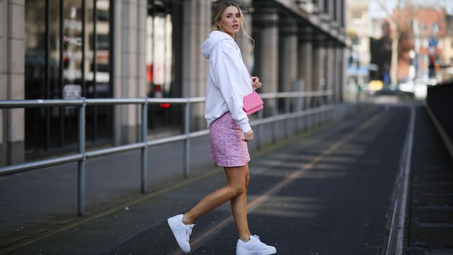 Scarlett Gartmann con falda de flores, sudadera blanca y zapatillas Puma en Dusseldorf