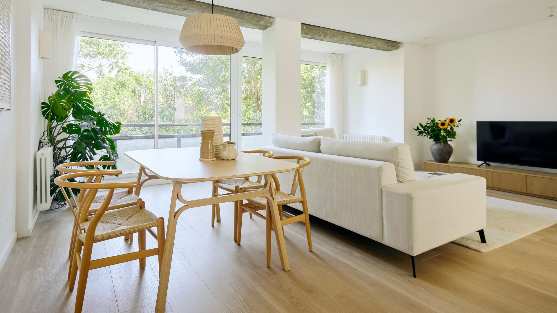 Salón con zona de estar y comedor en madera y blanco