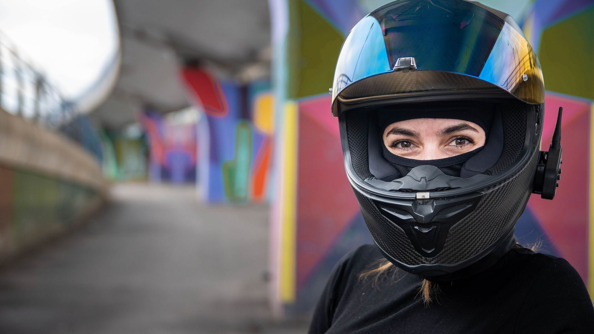 Una chica con un casco de moto y un intercomunicador
