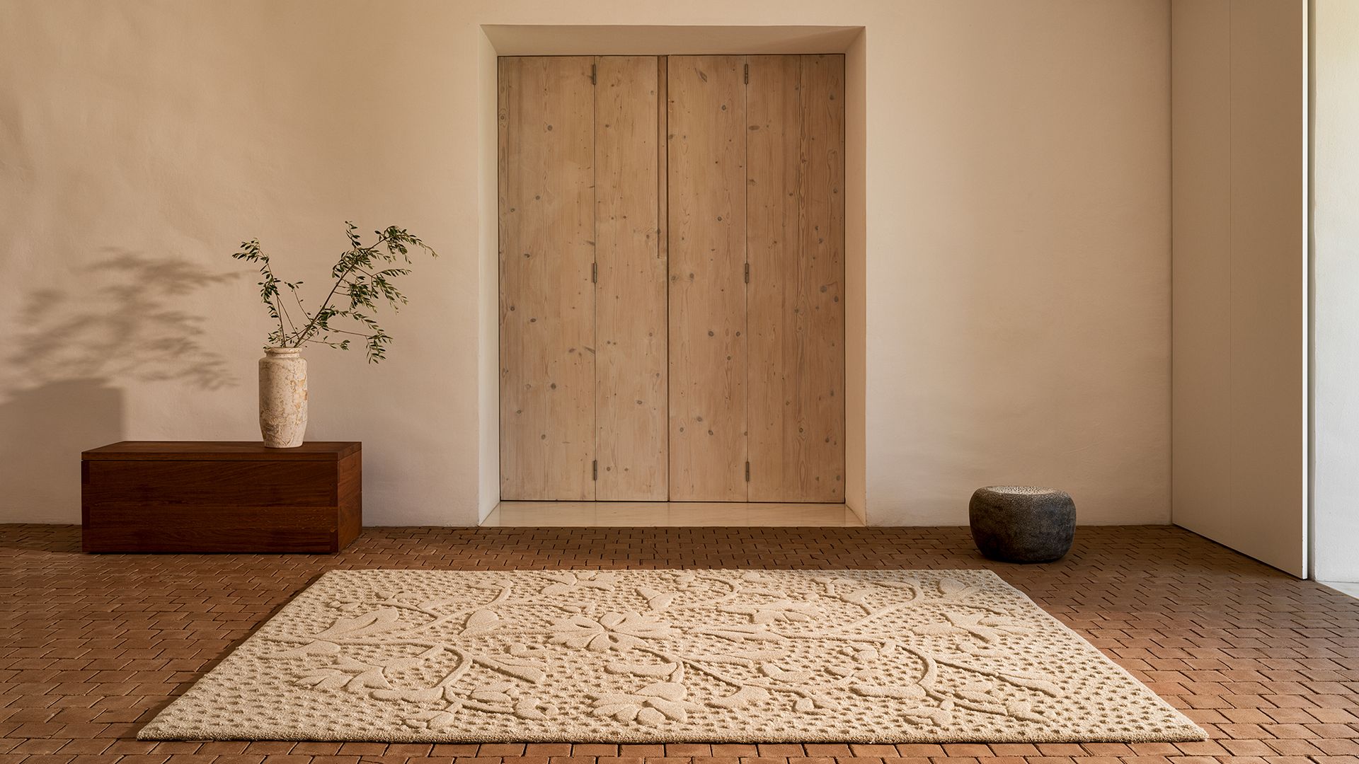 Recibidor con suelo de baldosas de barro, puerta de madera, alfombra beige cuadrada 
