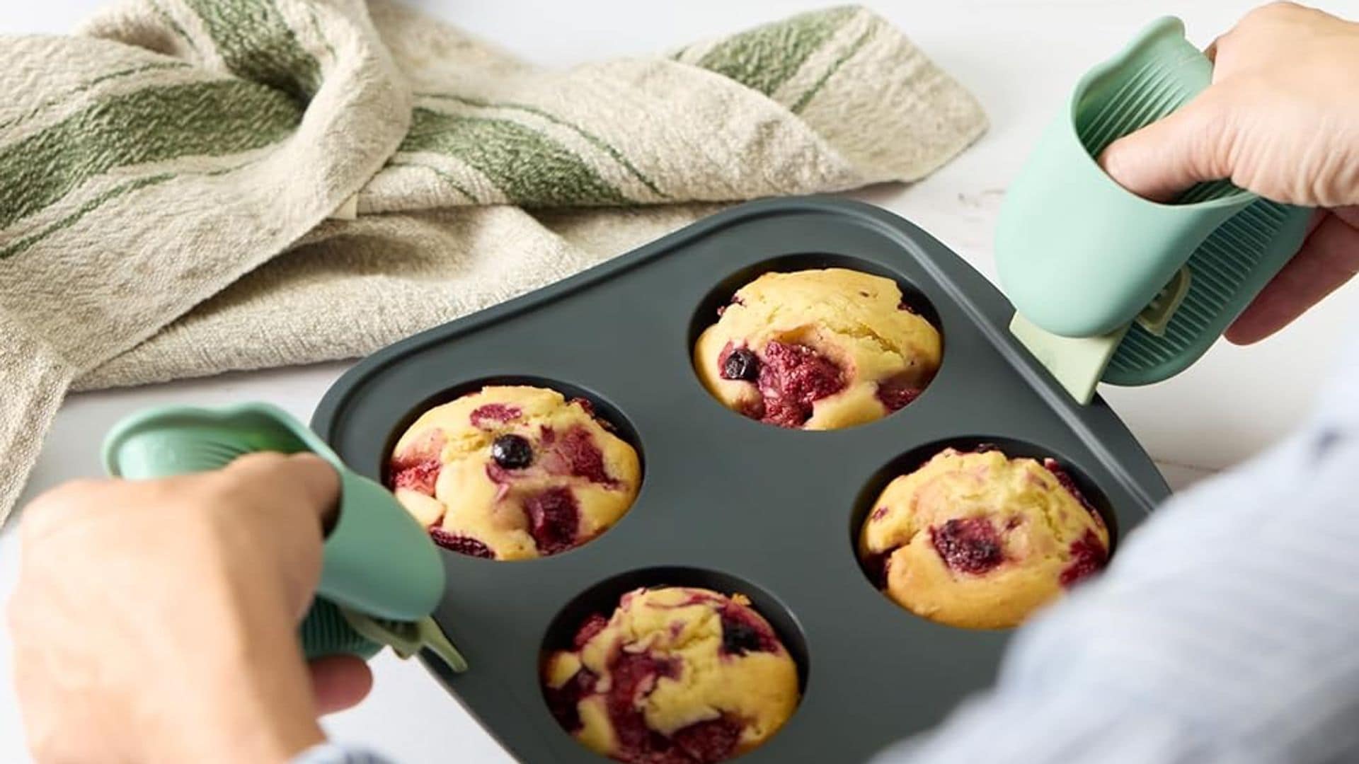 Mujer con manoplas de dedo cogiendo un molde de muffins de la air fryer